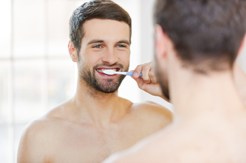 man brushing teeth to avoid gingivitis