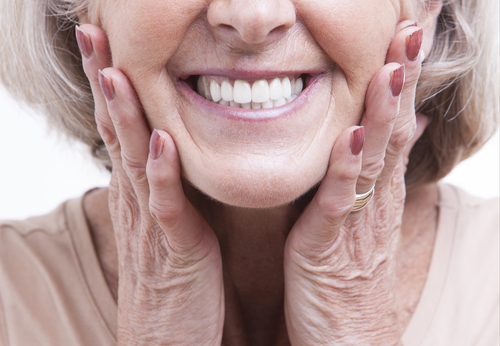 old woman showing off her dentures.