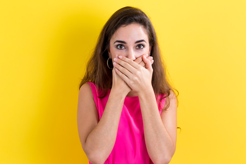 Young woman covering her mouth