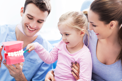 child playing with fake set of teeth at dentist office