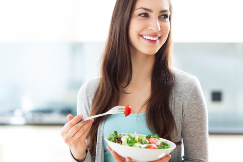 woman smiling eating a salad