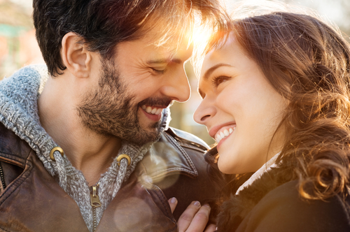 happy young couple looking at each other and smiling outdoor