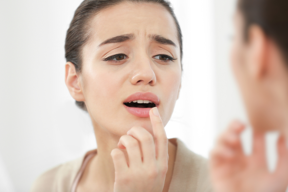 woman touching lips experiencing numbness after a dental appointment