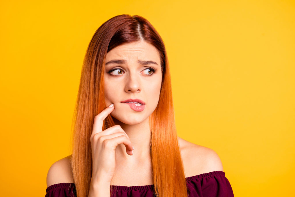 Woman concerned and biting her cheek