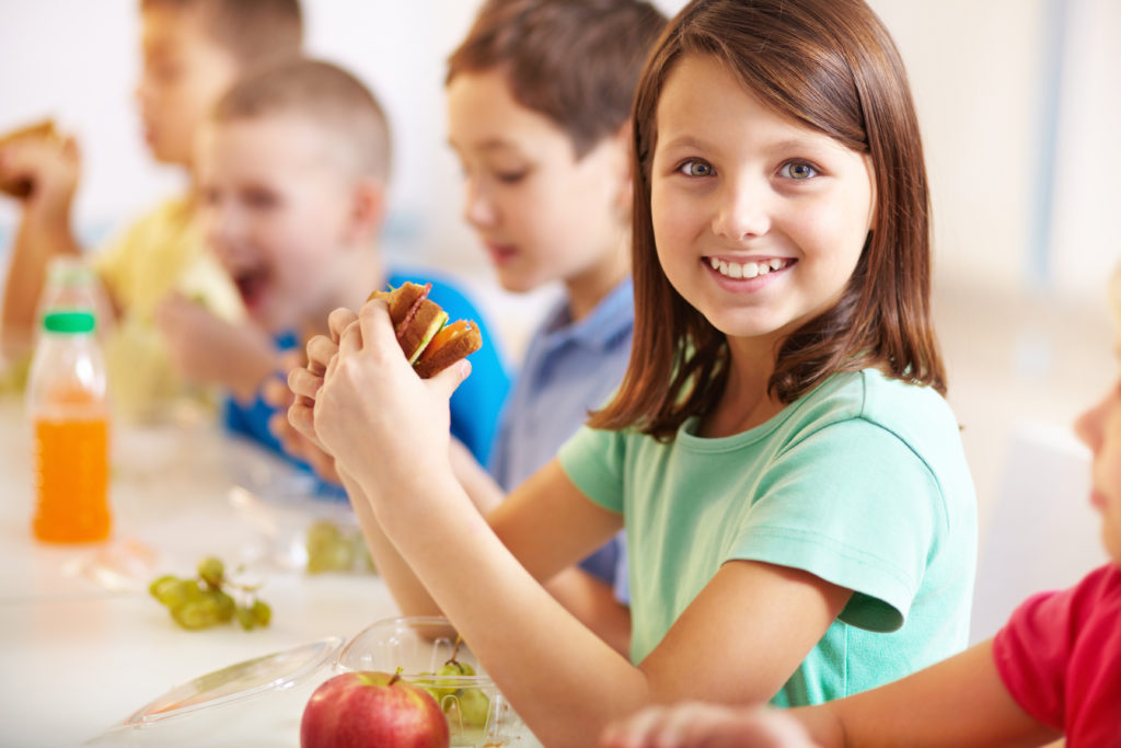 Children eating healthy school lunches. 