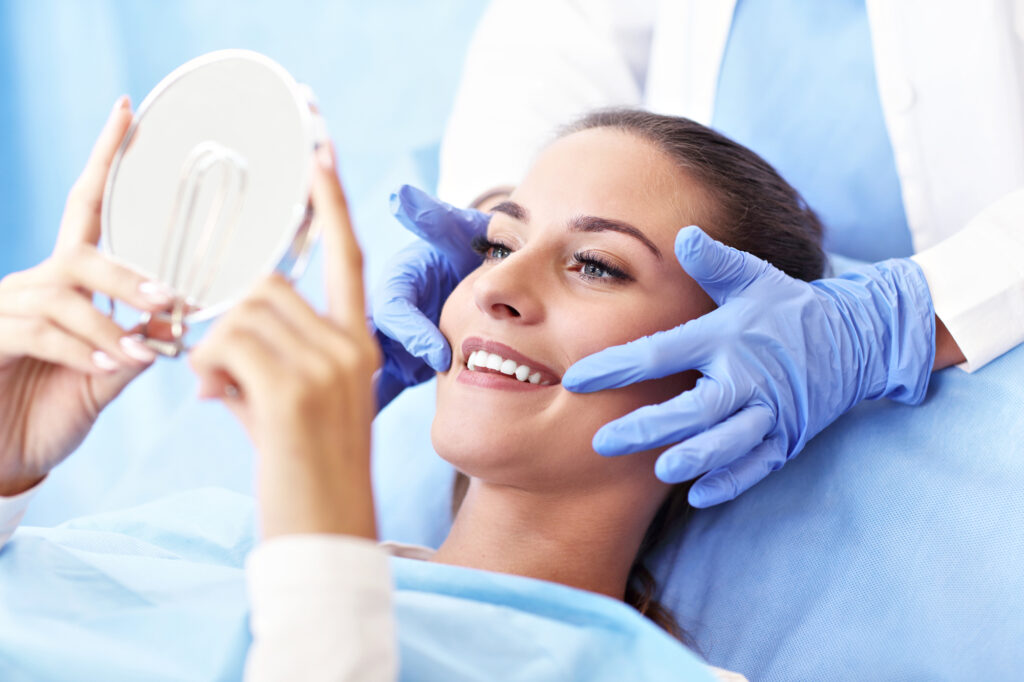 Woman whitening teeth with dental implant. 