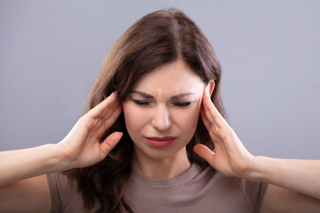 Woman with a headache and jaw pain.