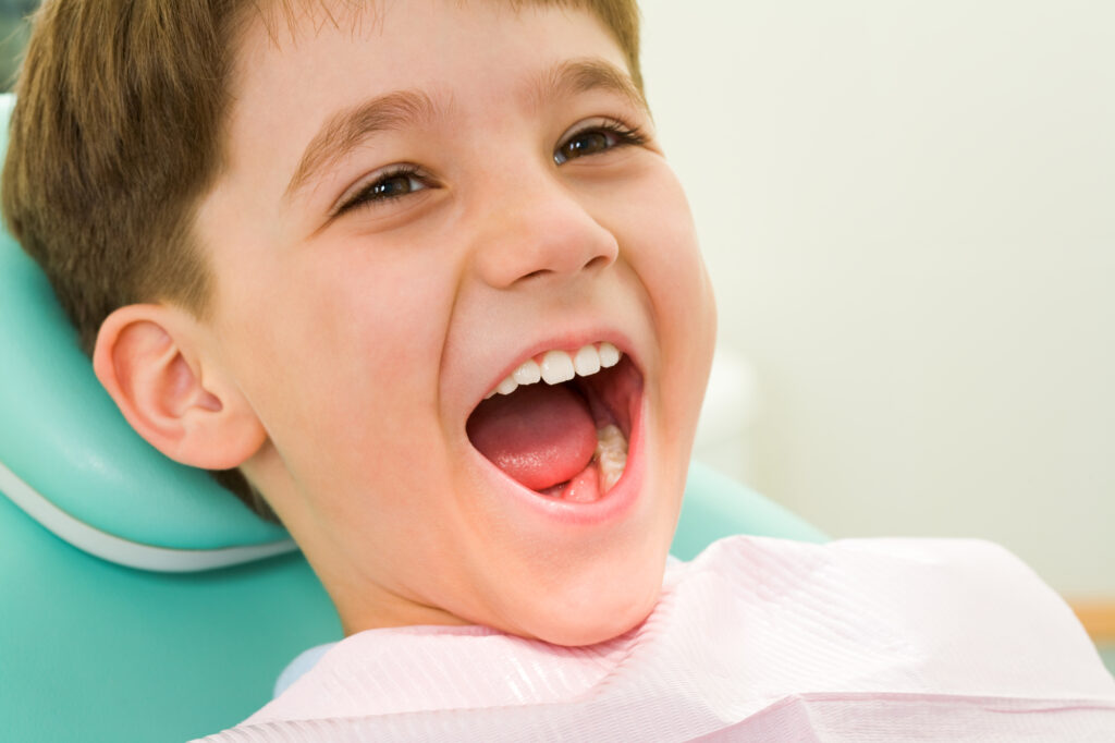 Happy child getting a cavity filled at the dentist.