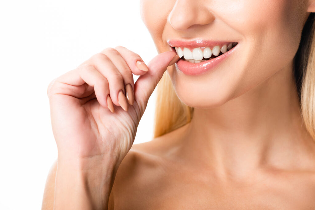 Woman touching Lumineers veneer. 